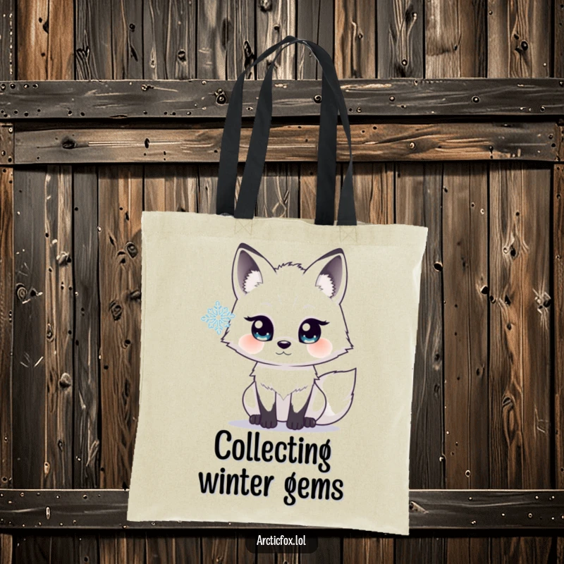 Funny tote bag showing an arctic fox with wide, bright eyes, looking with fascination at a delicate snowflake floating nearby.